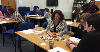 People sitting round tables during a training session.