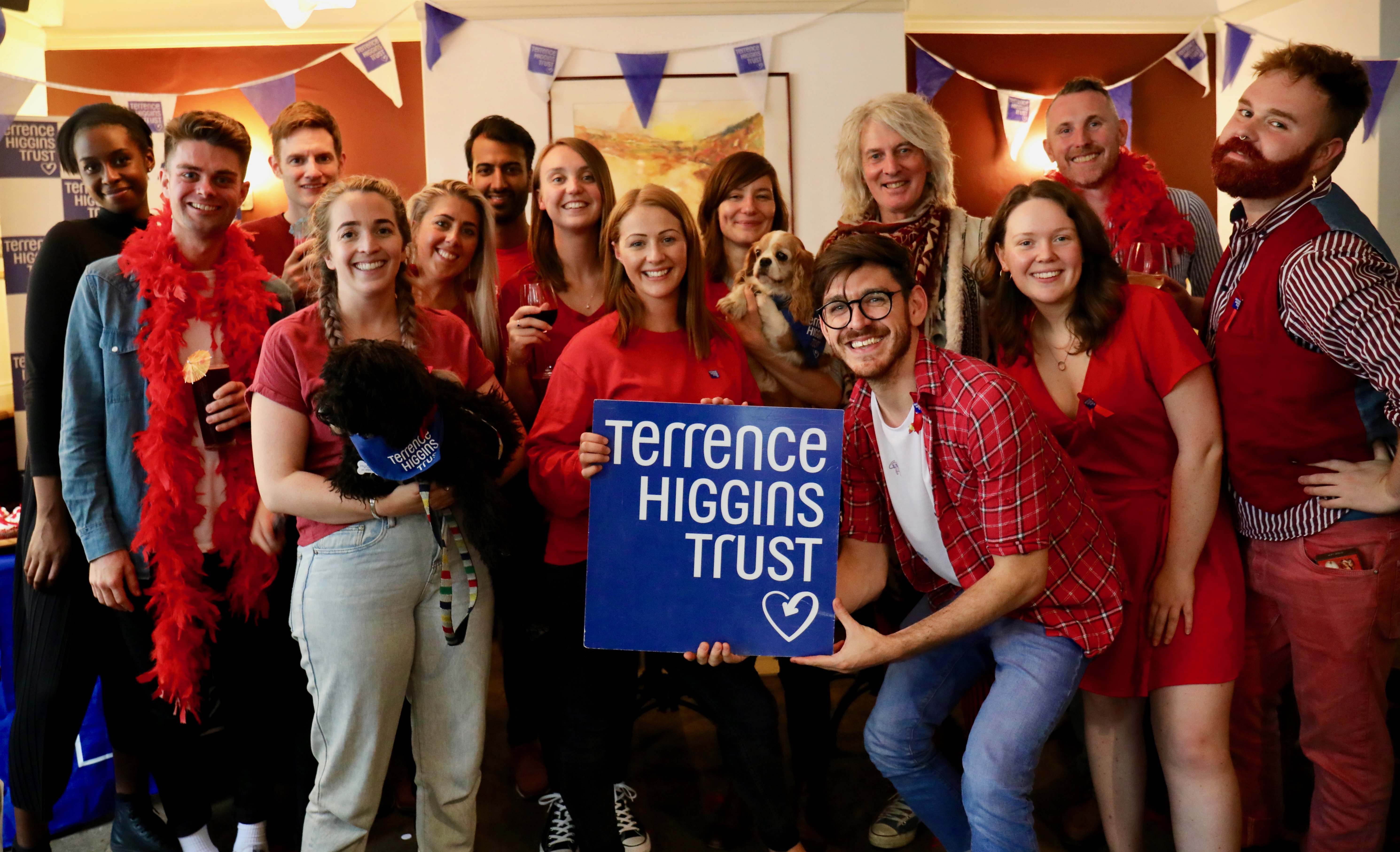 Group wearing red, holding THT logo