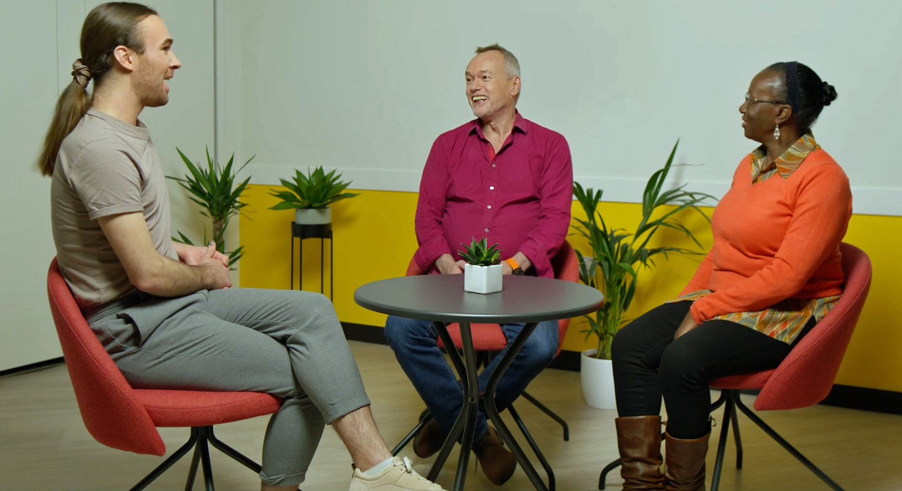 Three people sat around a table