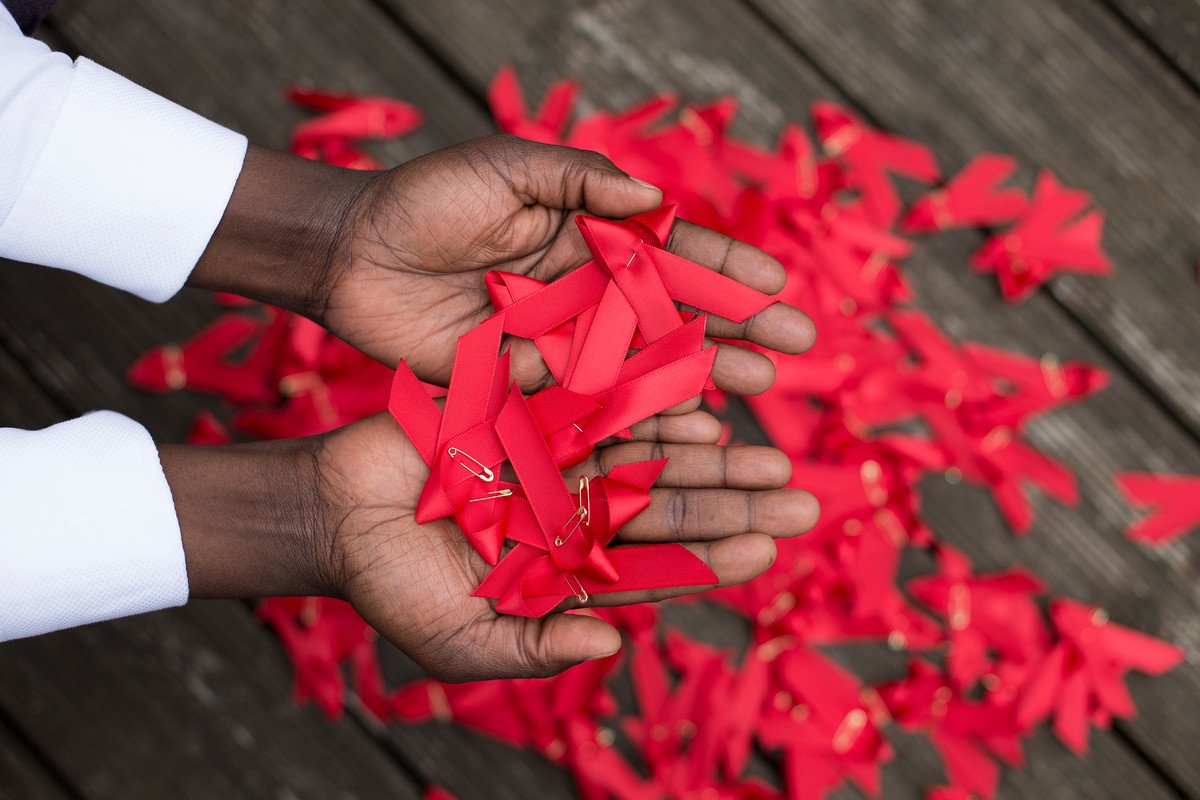 World AIDS day red ribbons in hands